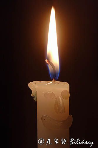 paląca się świeca z uśmiechniętą twarzą